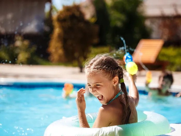 Niña jugando en la piscina del campamento