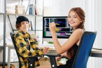 cheerful-pretty-teenage-girl-and-her-brother-smiling-at-camera-when-sitting-at-desk-and-doing-homework-for-computer-science-class cheerful-pretty-teenage-girl-and-her-brother-smiling-at-camera-when-sitting-at-desk-and-doing-homework-for-computer-science-class